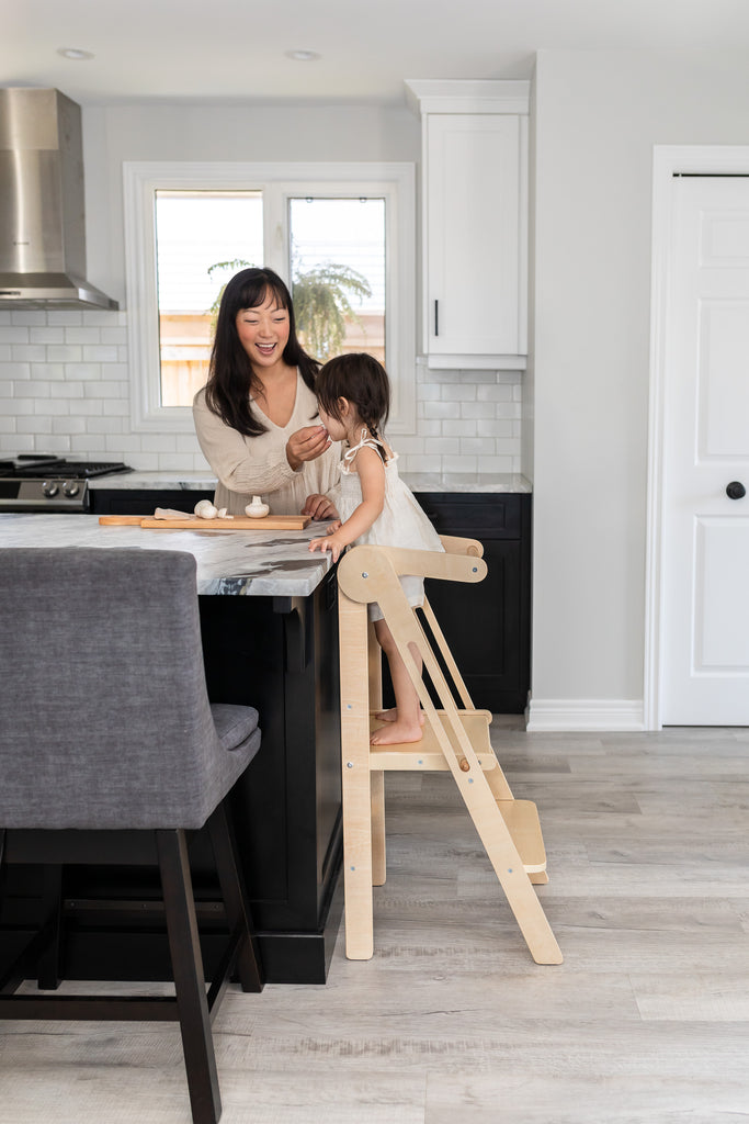 Mother and toddler share food and enjoy relationship on their children's learning tower