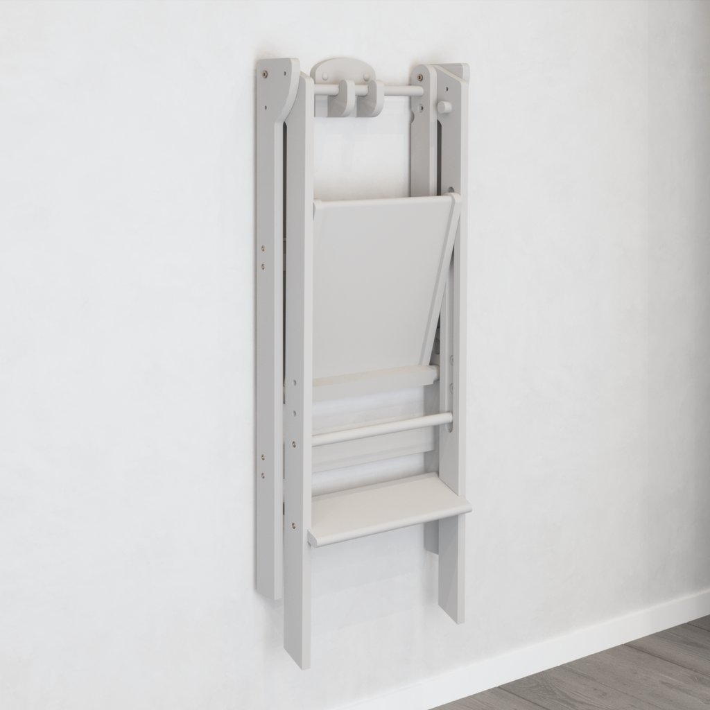 A white wall mount holding a folding learning tower suspended in the air for easy storage. 
