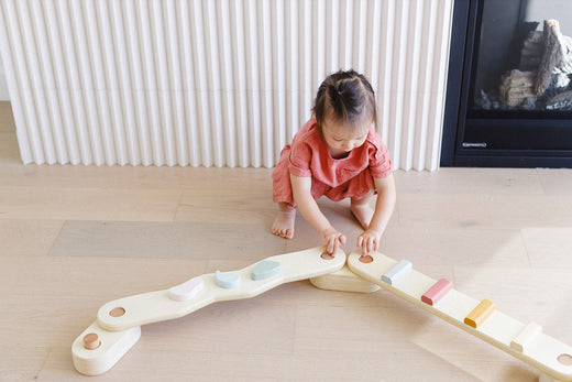 a little girl playing on the balance beam