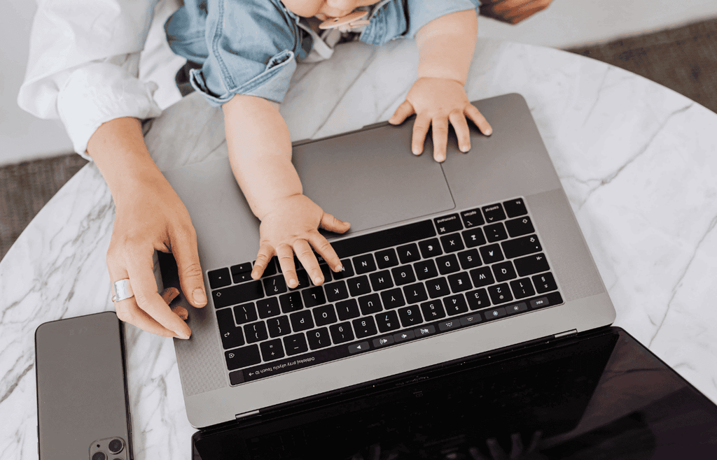 a toddler grabs the laptop