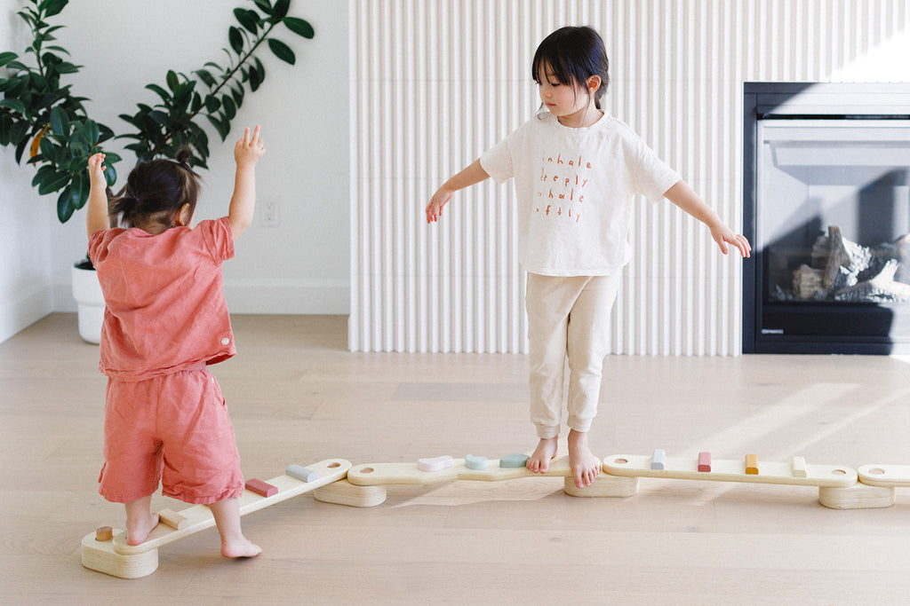 the kids are playing on the balance beam set