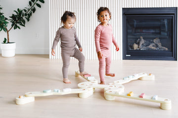 the kids are trying to balance on the beam set