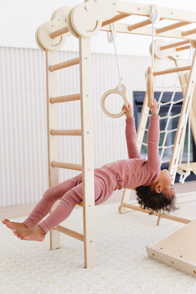 the little girl is hanging while holding the ring set 