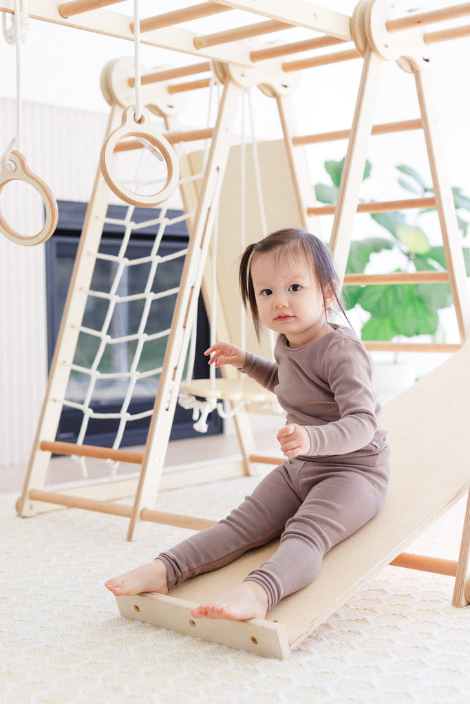 the little girl is sitting on the slide