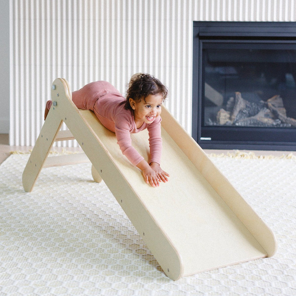 a little girl is sliding down