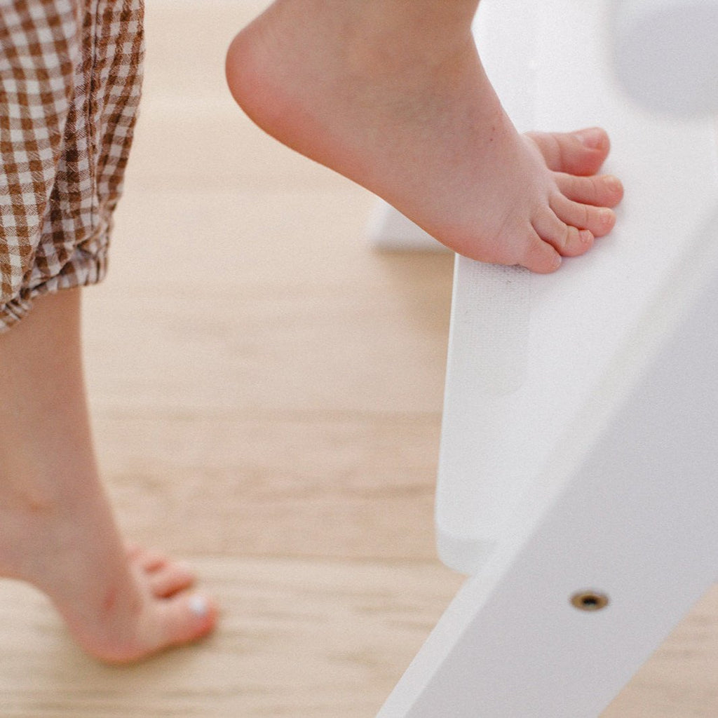 A close up of a girls toes going up into her learning tower with the anti slip strips on the step. 