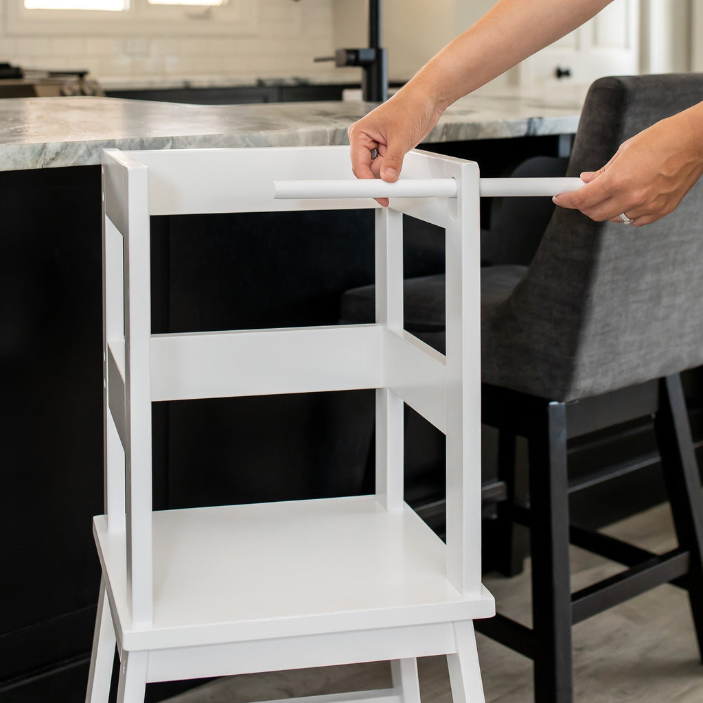 women demonstrating how to easily remove the safety bar for older children using their learning tower