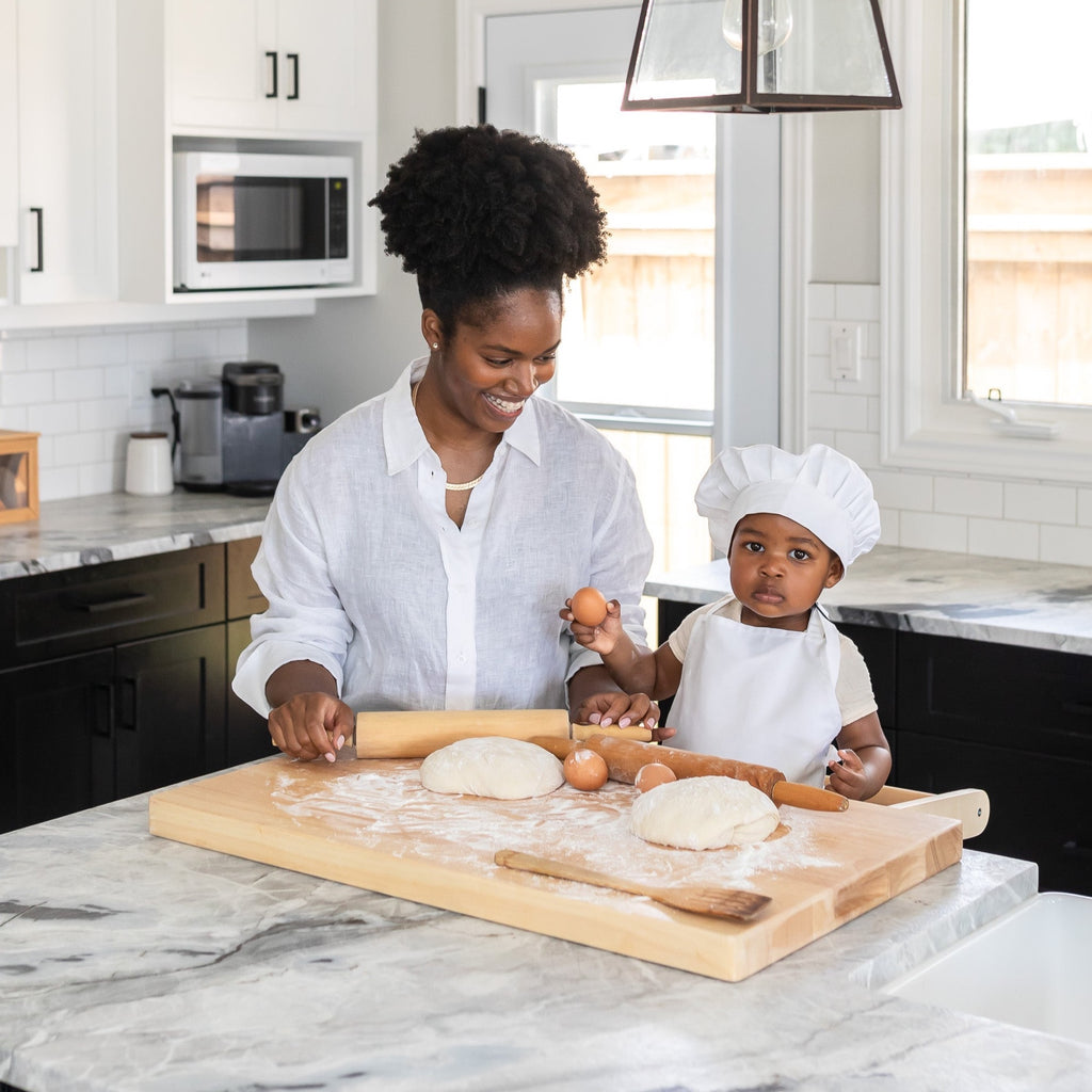 Mother and Child using Montessori Toddler Learning Tower to bake in kitchen