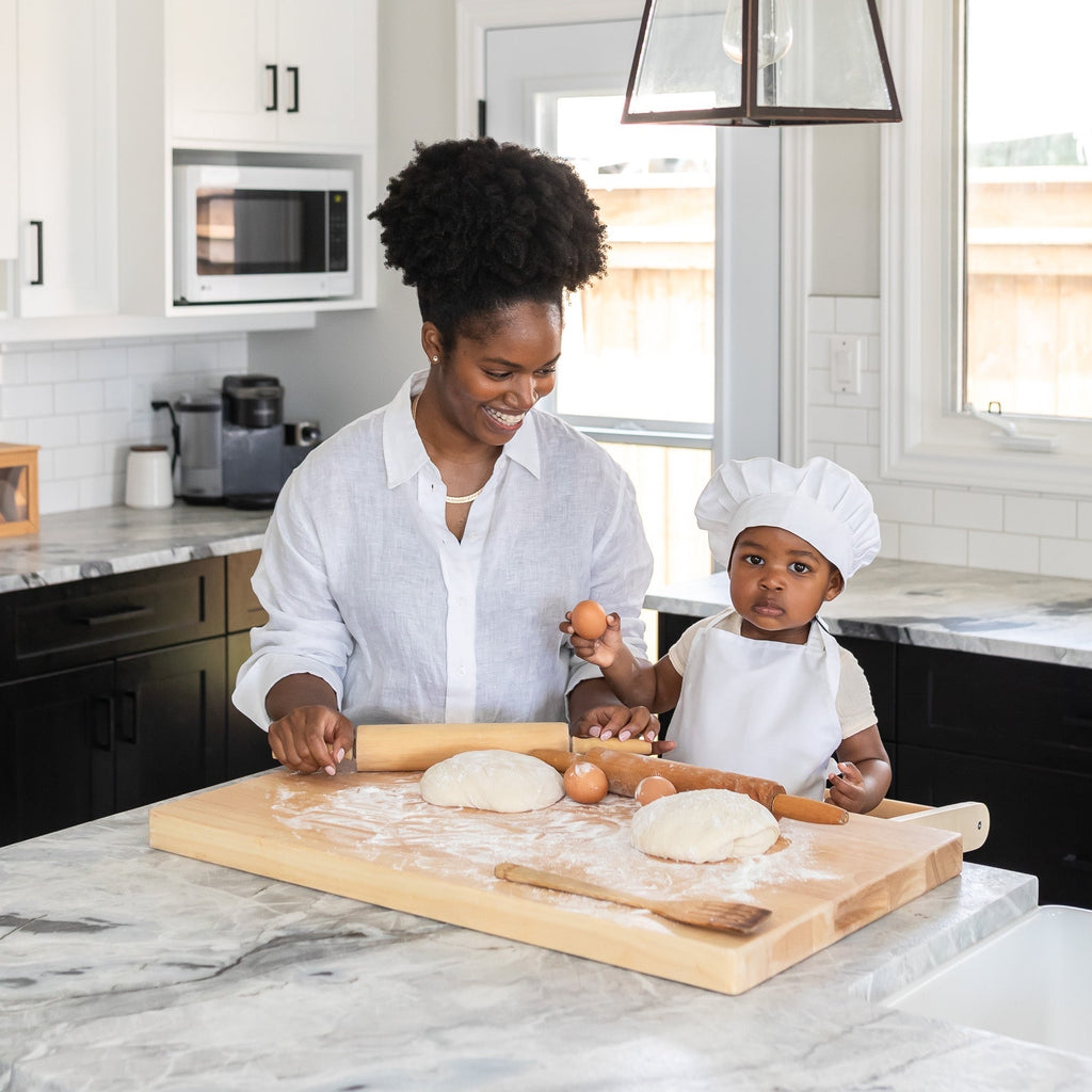 Mother and Child using Montessori Toddler Learning Tower to bake in kitchen
